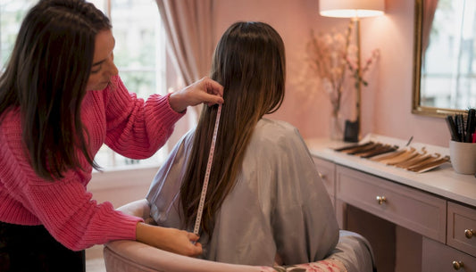 Stylist measuring hair length in salon